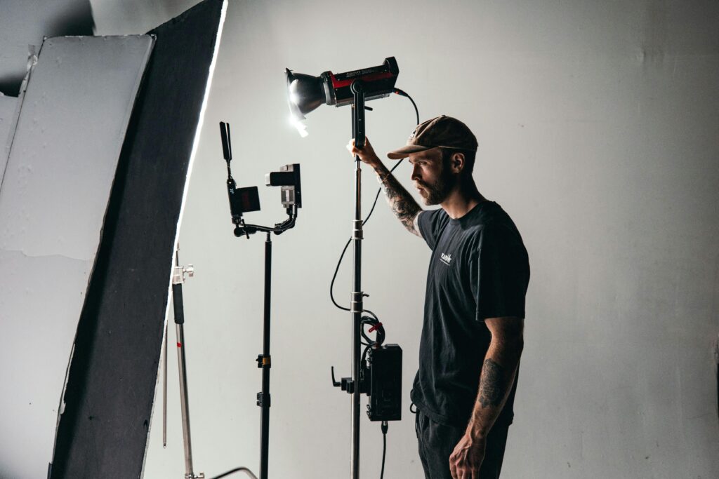 A cinematographer adjusting studio lighting on a film set, creating optimal conditions for filming.